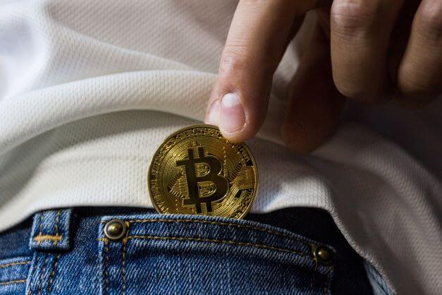 Crypto coin being placed in pocket